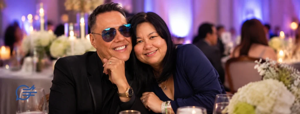 TV presenter Gok Wan sitting with his sister, childcare solicitor Oilen Wan, at a formal event.