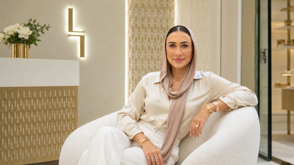 Emily Abraham: The Woman Behind Love Luxury’s Rise From a Knightsbridge Storefront to a Dubai Flagship Emily Abraham, co-founder of Love Luxury, seated inside the brand's luxury boutique in Dubai wearing an elegant neutral outfit and headscarf.